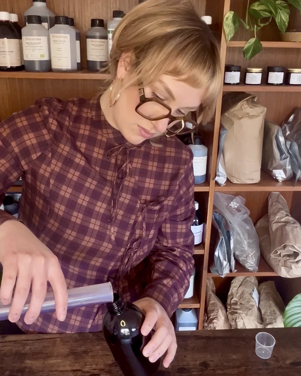Ellie Rose Grimsdale, Medical Herbalist, preparing a herbal tincture at her dispensary bench